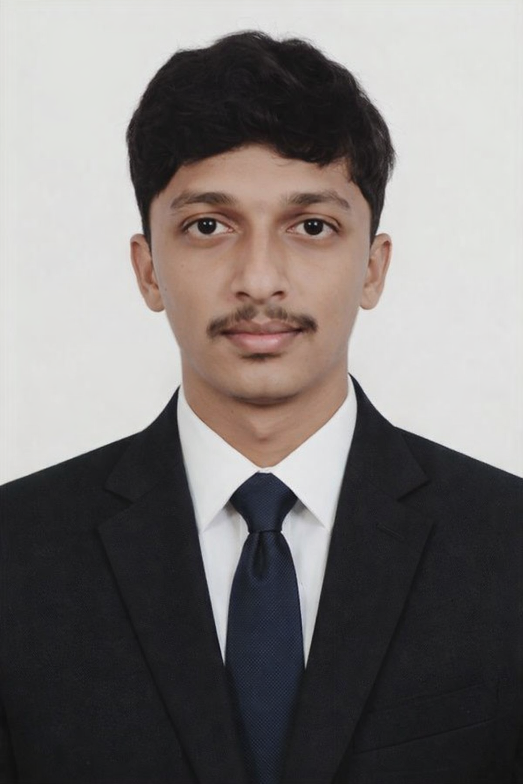 Portrait of a woman with dark hair and green leaves background
